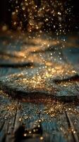 Sparkling golden particles scattered on a textured wooden surface in a softly lit environment photo