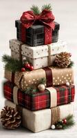 Festive wrapped gifts stacked together with holiday decorations and pine branches in a cozy setting photo