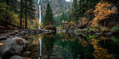 Stunning waterfall cascades into a serene lake framed by autumn foliage in a tranquil forest photo