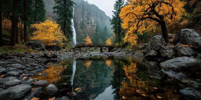 Autumn colors reflect in tranquil waters near a historic bridge by a waterfall in a serene forest setting photo