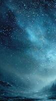 Starry night sky illuminated by falling snow over a winter landscape with snowy trees and a mystic atmosphere photo