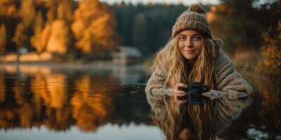 Young woman enjoys serene autumn morning by the lake while capturing nature with her camera photo