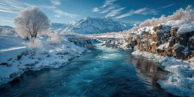Snow-covered river flows through mountainous landscape under clear blue sky during winter season photo