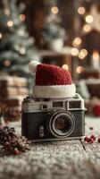 Vintage camera with a red knit hat placed on top, surrounded by festive decorations in a cozy holiday setting photo