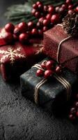 Colorful holiday gifts decorated with red berries and pine cones arranged on a dark textured surface photo