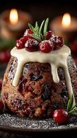 Delicious holiday pudding topped with fresh cranberries and cream served with candles in the background at a festive gathering photo