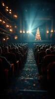 Audience enjoying a holiday performance at a theater with a glowing Christmas tree in the background photo