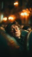 Man with glasses resting indoors among a crowd during an evening event photo