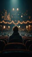 Audience member enjoying a performance in a dimly lit theater with warm lights and a cozy atmosphere photo