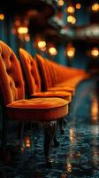 Warm orange chairs line a dimly lit venue creating an inviting atmosphere for gatherings and events photo