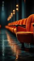 Rows of vintage orange chairs in a dimly lit hallway creating a nostalgic atmosphere photo
