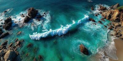 Beautiful turquoise ocean waves crashing on rocky shoreline during sunny day in coastal area photo