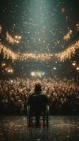 Audience captivated by a speaker in a wheelchair during a grand event filled with lights and excitement photo