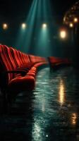 Elegant red theater seats illuminated by soft beams of light in a vintage performance space during the evening hours photo