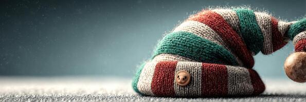 Striped Christmas elf hat resting on a surface with festive decorations in the background creating a cozy holiday atmosphere photo
