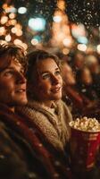 Two friends enjoying a movie night under twinkling lights in an outdoor setting while sharing popcorn during the festive season photo