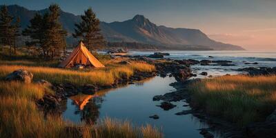Serene camping spot near the ocean at sunset with mountains in the background photo