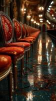 Elegant red chairs line a glossy floor in a grand hall illuminated by soft lights during an evening event photo