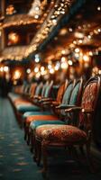 Beautifully decorated vintage chairs in a grand theater illuminated by warm lights during an evening performance photo