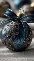 Elegant blue and gold ornament decorated with intricate designs resting on a soft fabric backdrop during the holiday season photo