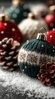 Holiday decorations feature colorful ornaments and pine cones resting on a snowy surface photo