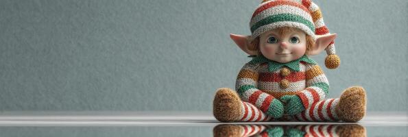 Adorable knitted elf doll sitting on a reflective surface in cozy indoor setting photo