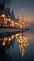 Twinkling holiday lights reflect in serene water at an enchanting winter evening photo