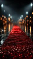 Red carpet glistens under lights on a rainy evening in an elegant outdoor setting photo