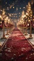 Snow-covered red carpet pathway lined with golden stanchions and twinkling lights during a festive winter evening photo