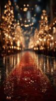 Elegant red carpet lined with illuminated trees in a festive night setting with a rain-soaked reflection photo