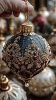 Ornate holiday ornament being held up in a festive market filled with decorative items photo