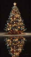Elegant Christmas tree adorned with ornaments and lights reflecting on a dark surface during winter festivities photo