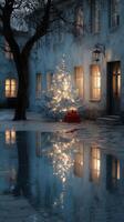 Winter evening with a glowing Christmas tree and warm lights reflecting on a snowy street photo
