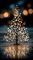 Glowing miniature Christmas tree with warm lights illuminating a dark background at night photo