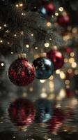 Brightly colored Christmas ornaments hang from a festive tree with sparkling lights reflecting on a serene surface photo