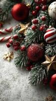 Holiday decoration featuring red and gold ornaments on evergreen branches with snow and candy canes photo