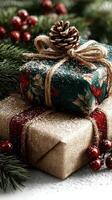 Festive holiday gift boxes decorated with twine and pine cones set among evergreen branches and red berries photo