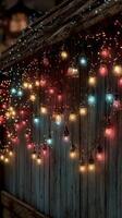 Colorful string lights illuminate an outdoor wooden wall during the evening in a cozy setting photo