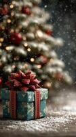 Festively wrapped gift box in front of a decorated Christmas tree during a snowy holiday evening photo