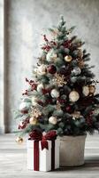 Beautifully decorated Christmas tree with ornaments, berries, and wrapped gift in stylish indoor setting during the holiday season photo