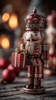 Colorful nutcracker figurine holds a gift in a cozy holiday setting with blurred lights in the background photo