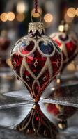 Intricate red glass ornament reflecting warm holiday lights in a festive setting photo