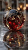Intricately designed red ornament reflecting city lights on a rainy surface during the festive season photo