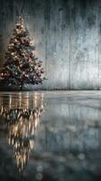 Decorative Christmas tree with lights and ornaments beside reflective surface in a minimalist setting photo
