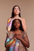 Two diverse women in serene pose with eyes closed and holographic light. Calm, harmony, unity, and inner peace. Concept of meditation, connection, energy, and healing aura. photo