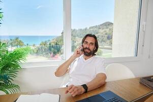 Man Working Remotely from Home Office with Scenic Window View photo