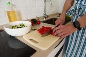 Man Preparing Fresh Salad in a Modern Home Kitchen Setting photo