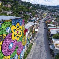 Vibrant large-scale mural showcasing artistic expression on a hillside community building amidst colorful structures and dense urban landscape surroundings photo