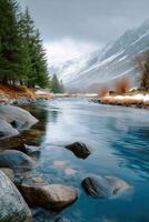 A river with rocks and snow on the ground photo