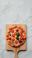 A small pizza on a wooden board with a wooden spatula photo